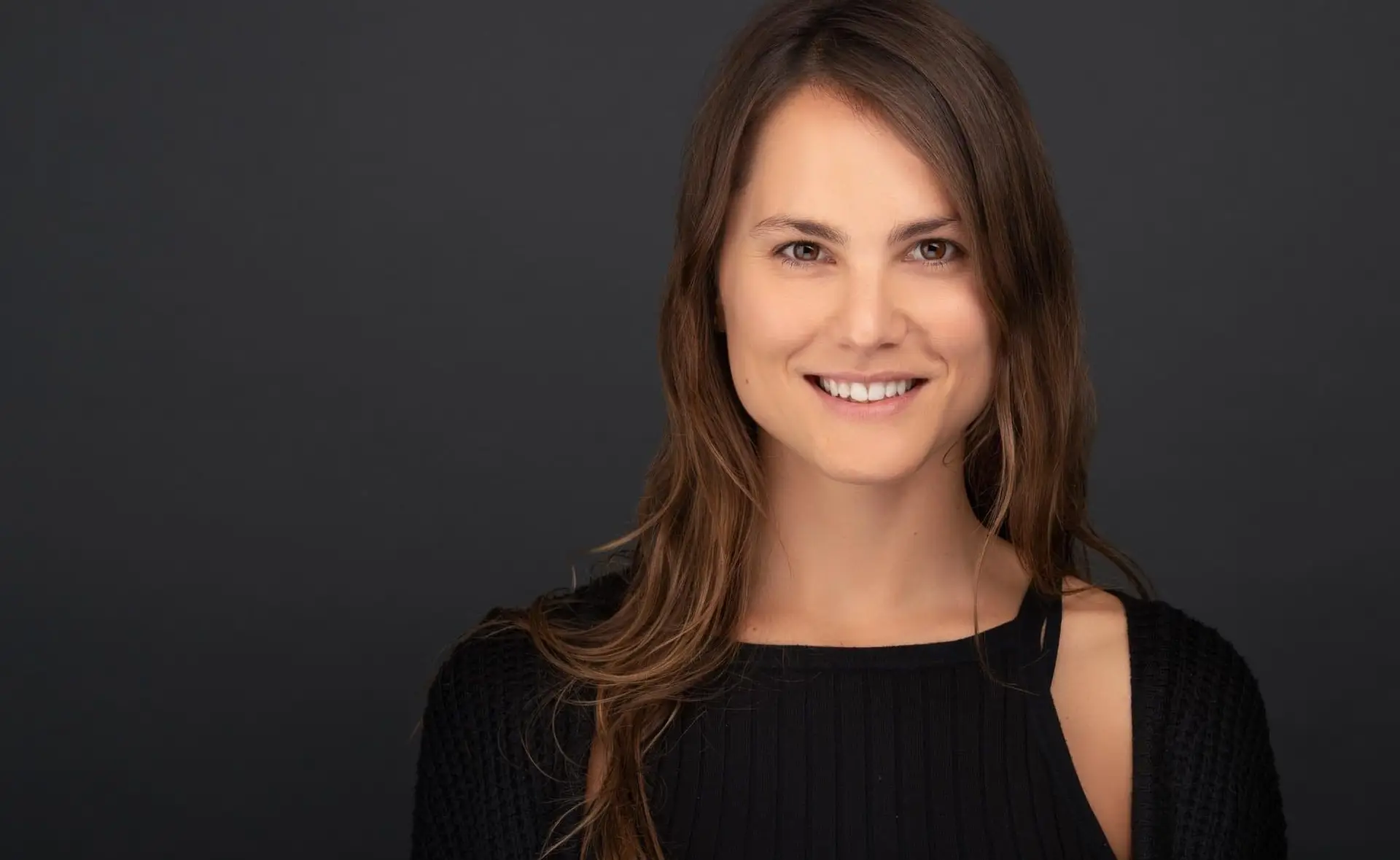 Headshot photography Sydney, woman with long hair on dark background