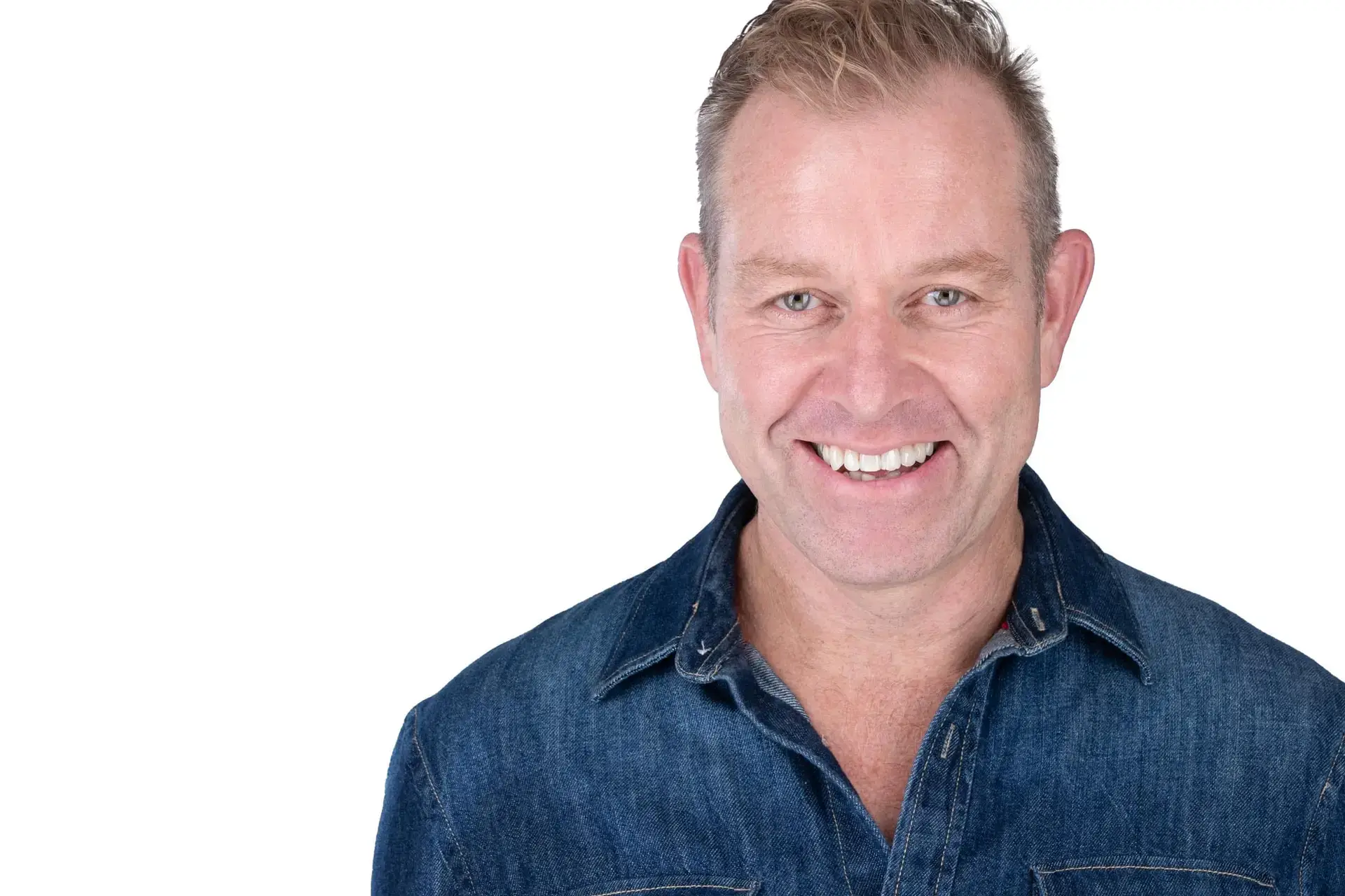 Headshot photography Sydney, smiling man in denim shirt on white background