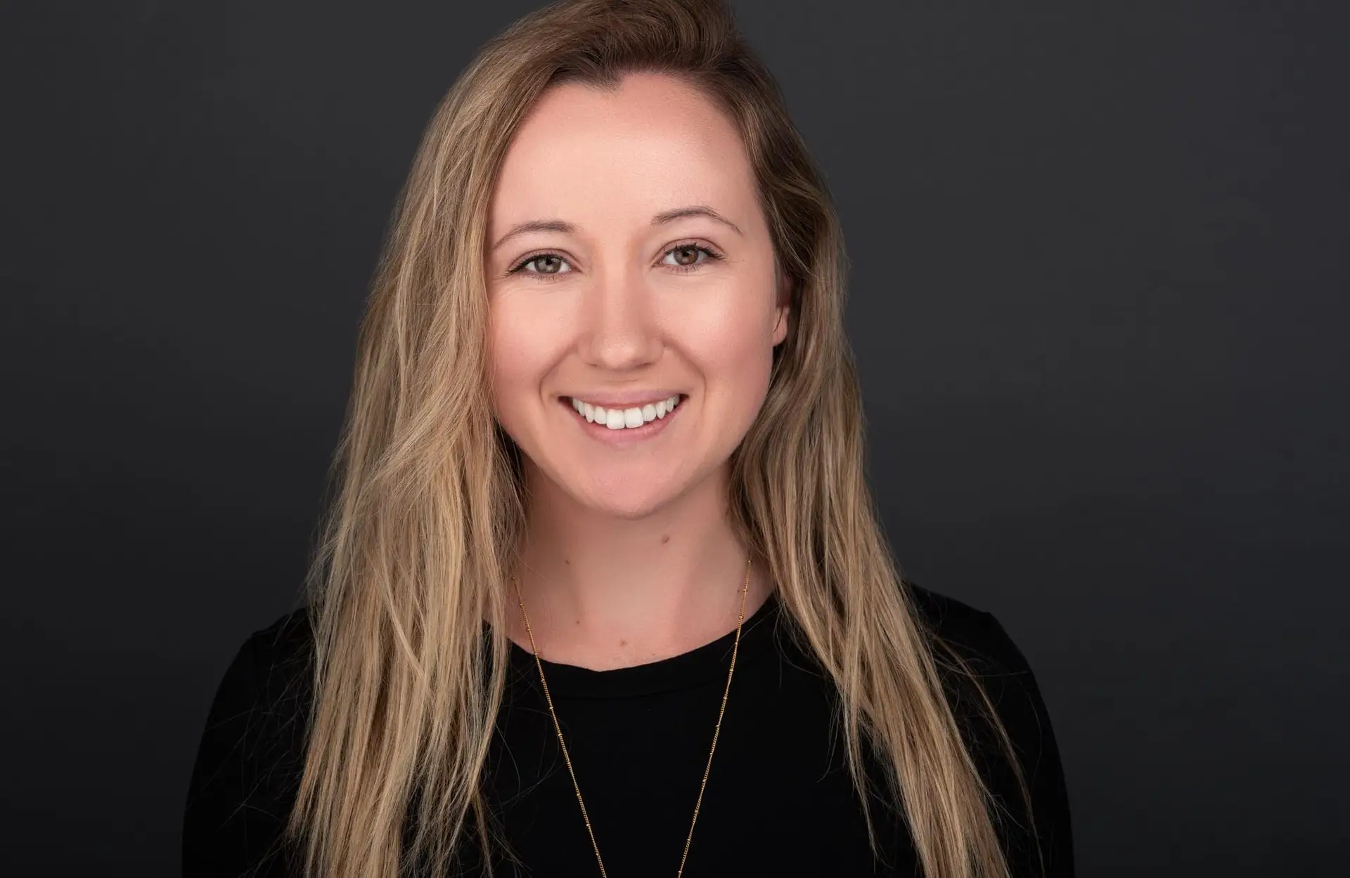 Professional headshot Sydney, smiling woman on dark background